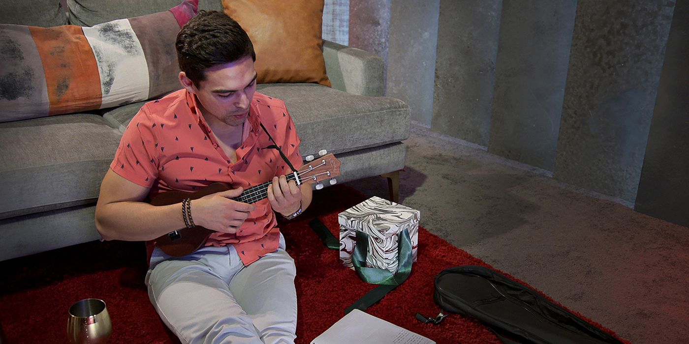 Sal sitting on the ground playing the ukulele in Love is Blind.
