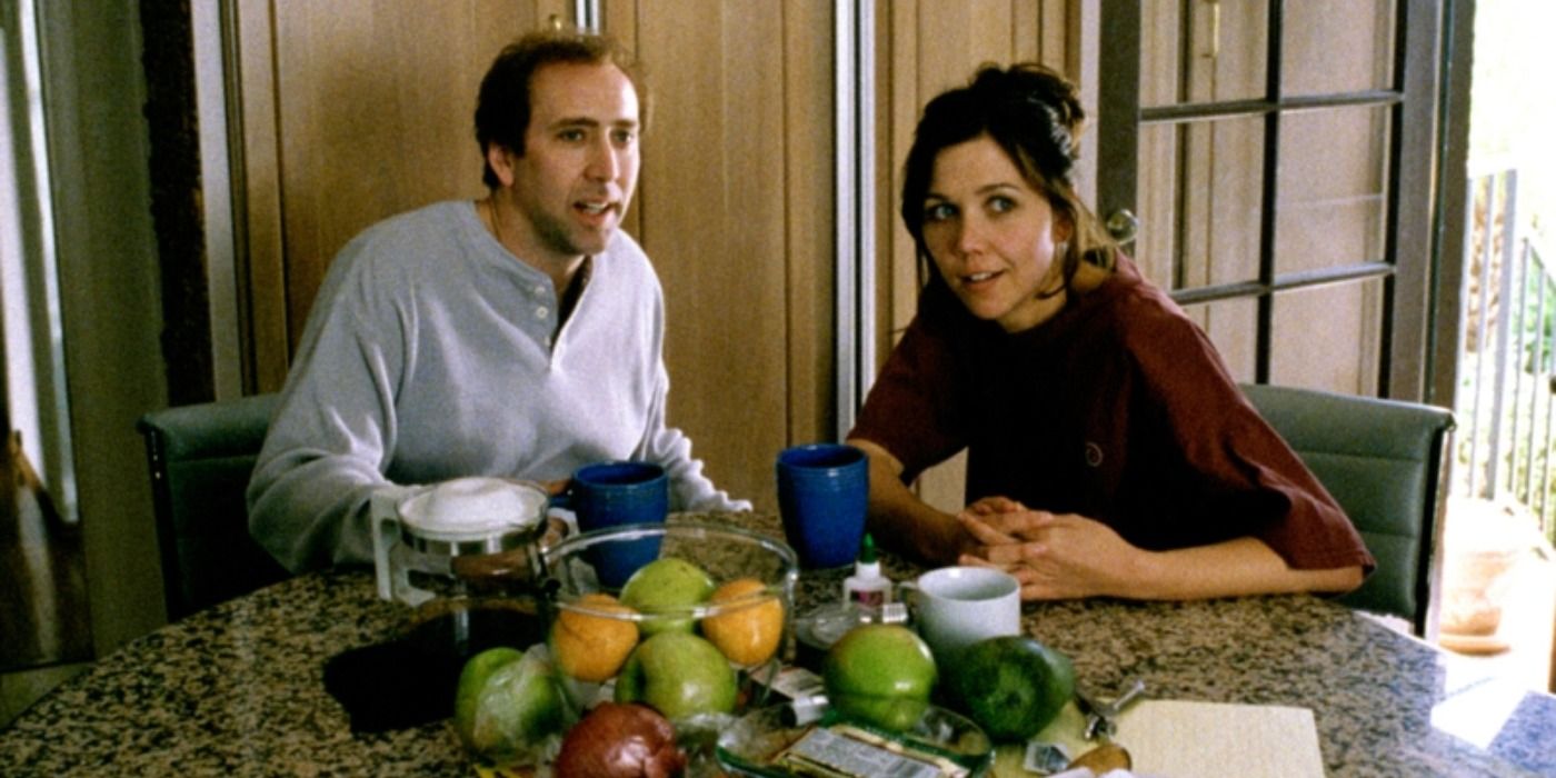 Maggie Gyllenhaal sitting at a kitchen counter with Nic Cage in Adaptation.