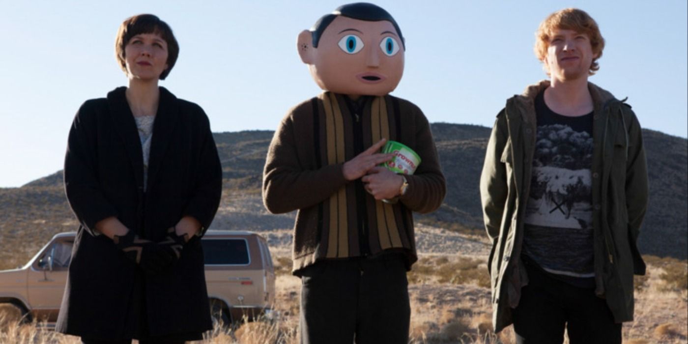 Maggie Gyllenhaal standing in the desert with two men in Frank.