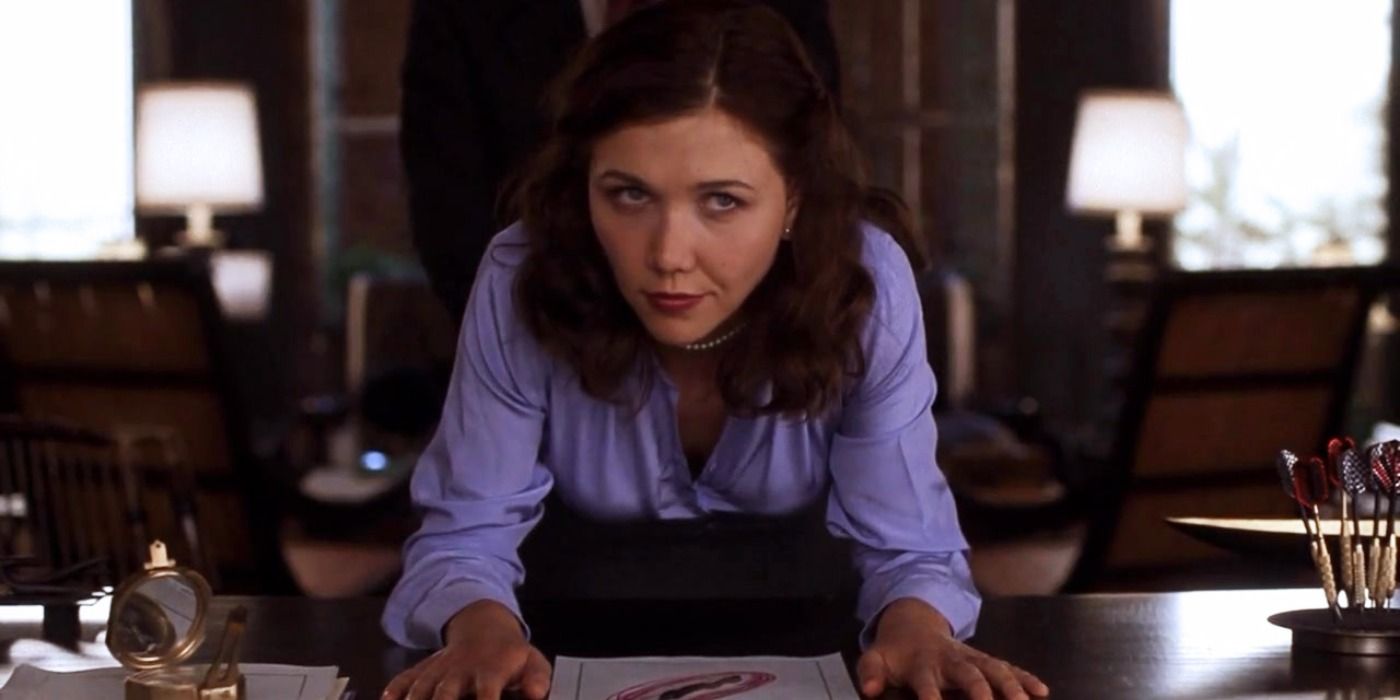Maggie Gyllenhaal sitting at a desk in Secretary.