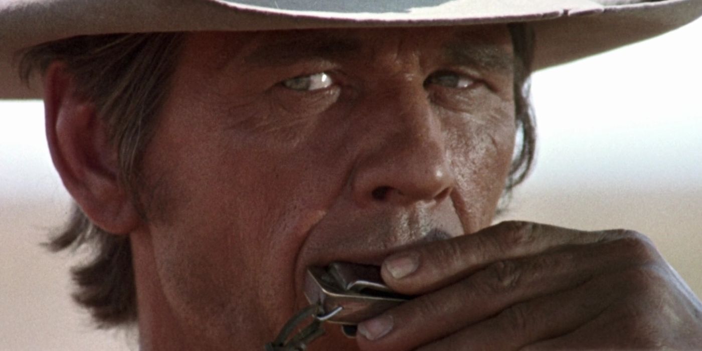 Charles Bronson as Harmonica playing the harmonica during his introduction in Once Upon a Time in the West