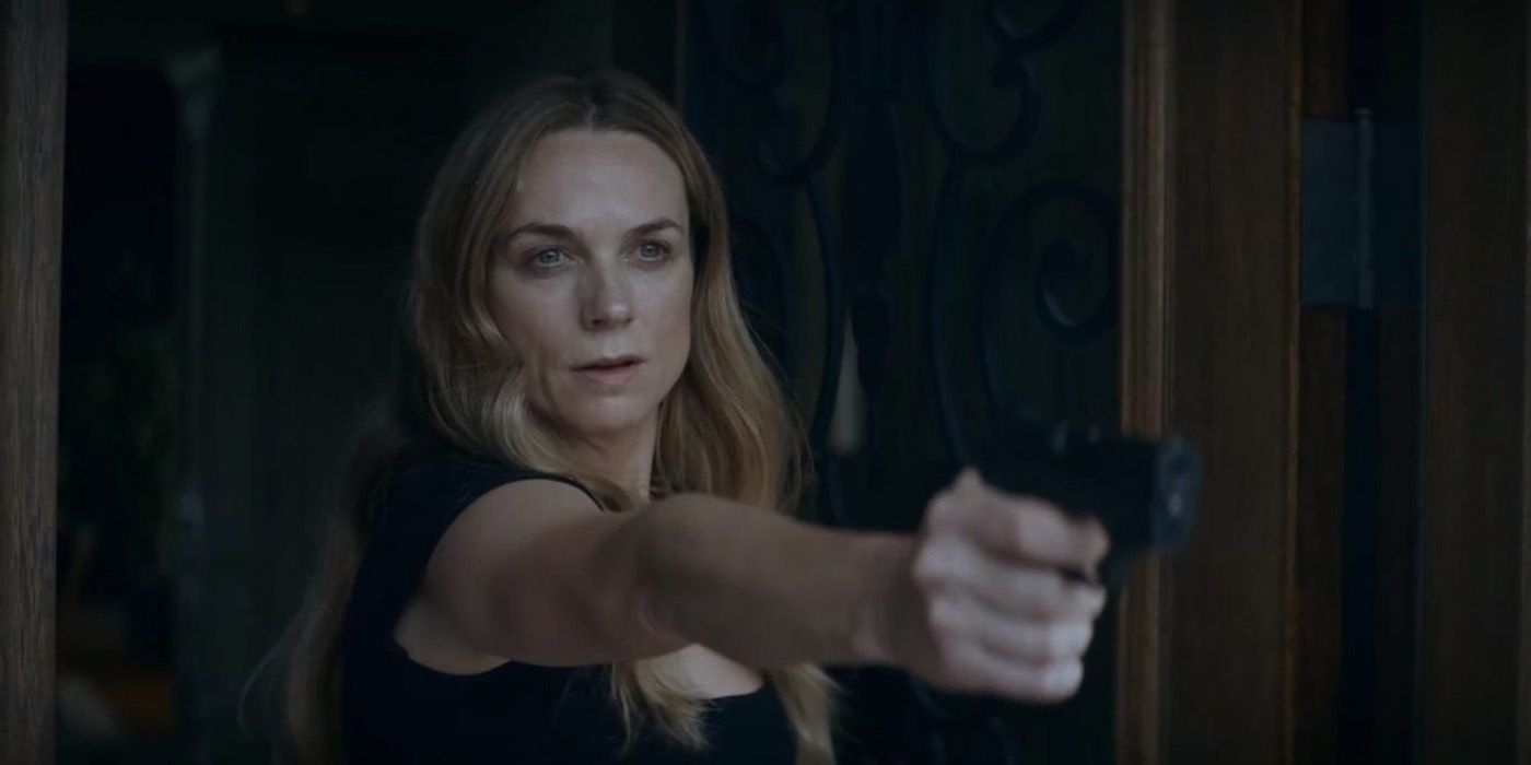 Molly from Ray Donovan at the doorway, pointing a gun looking angry.