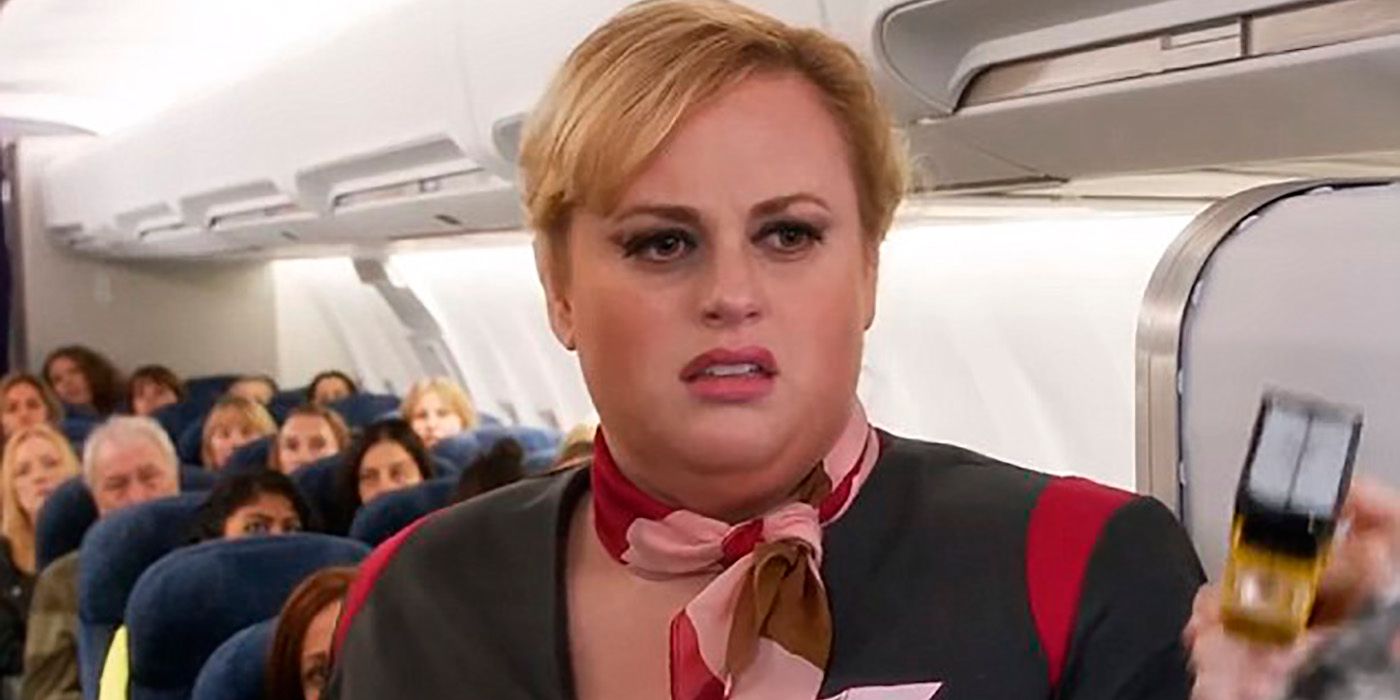 Rebel Wilson dressed as a flight attendant on a plane in Absolutely Fabulous.