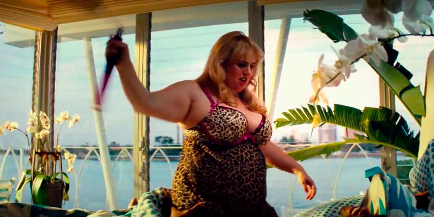 Rebel Wilson in leopard print lingerie on a bed, hand in the air in Pain &amp; Gain.