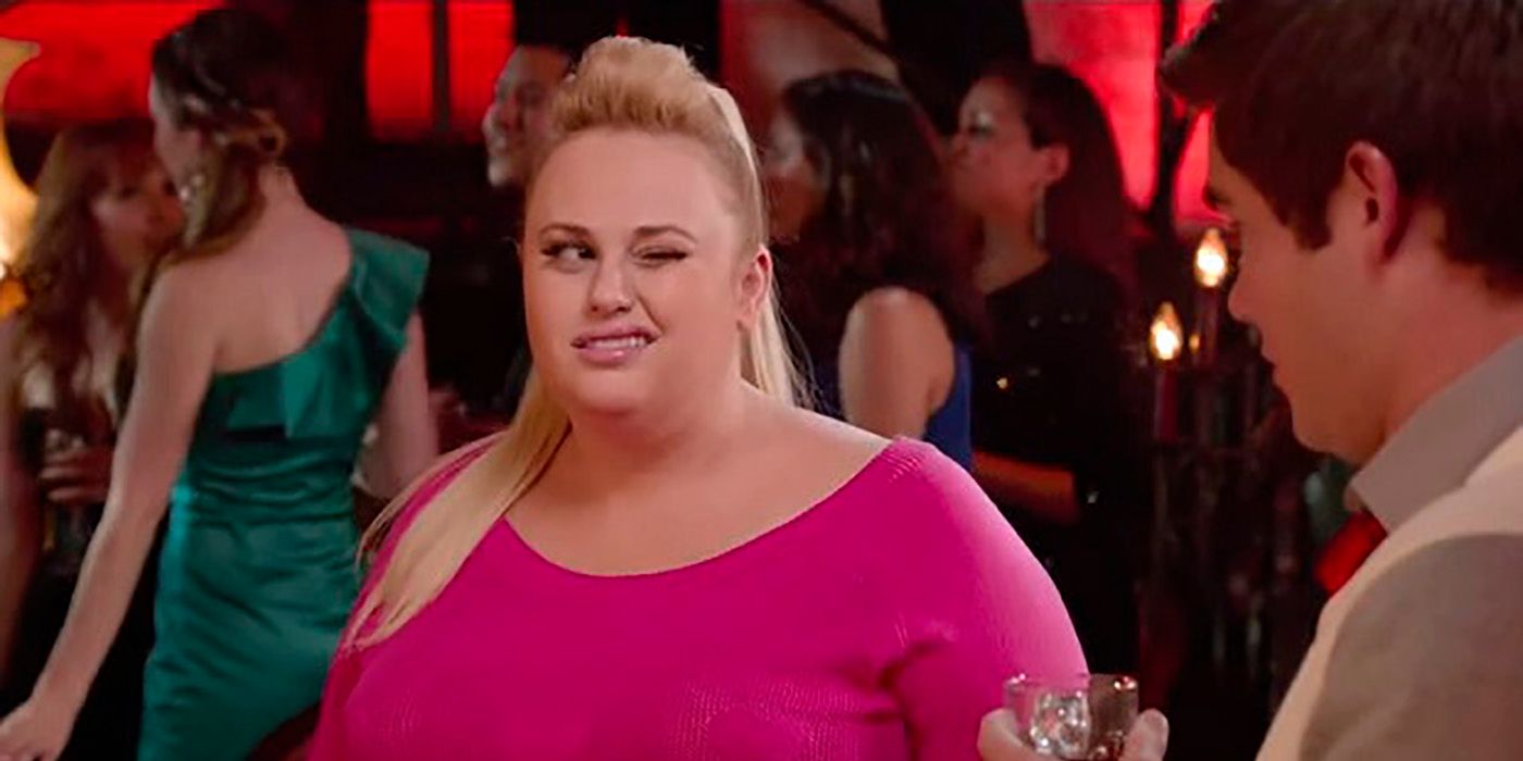 Rebel Wilson in pink, winking in a scene from Pitch Perfect.