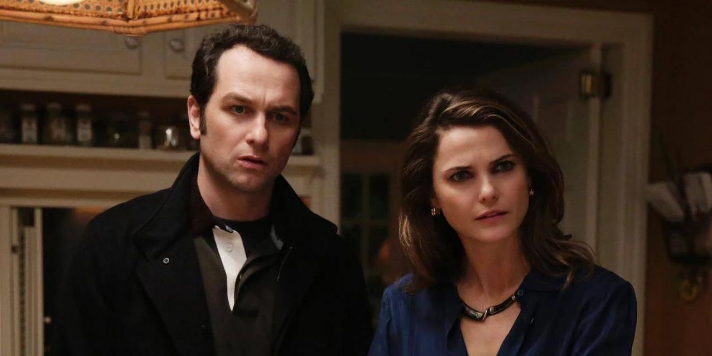 Matthew Rhys and Keri Russell listening to someone inside a house in The Americans