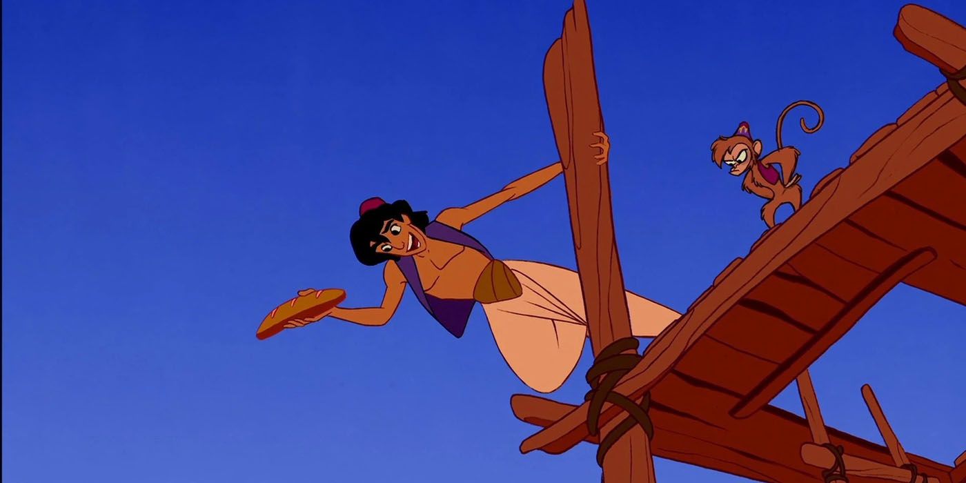 Aladdin and Abu hanging from a building to escape the guards