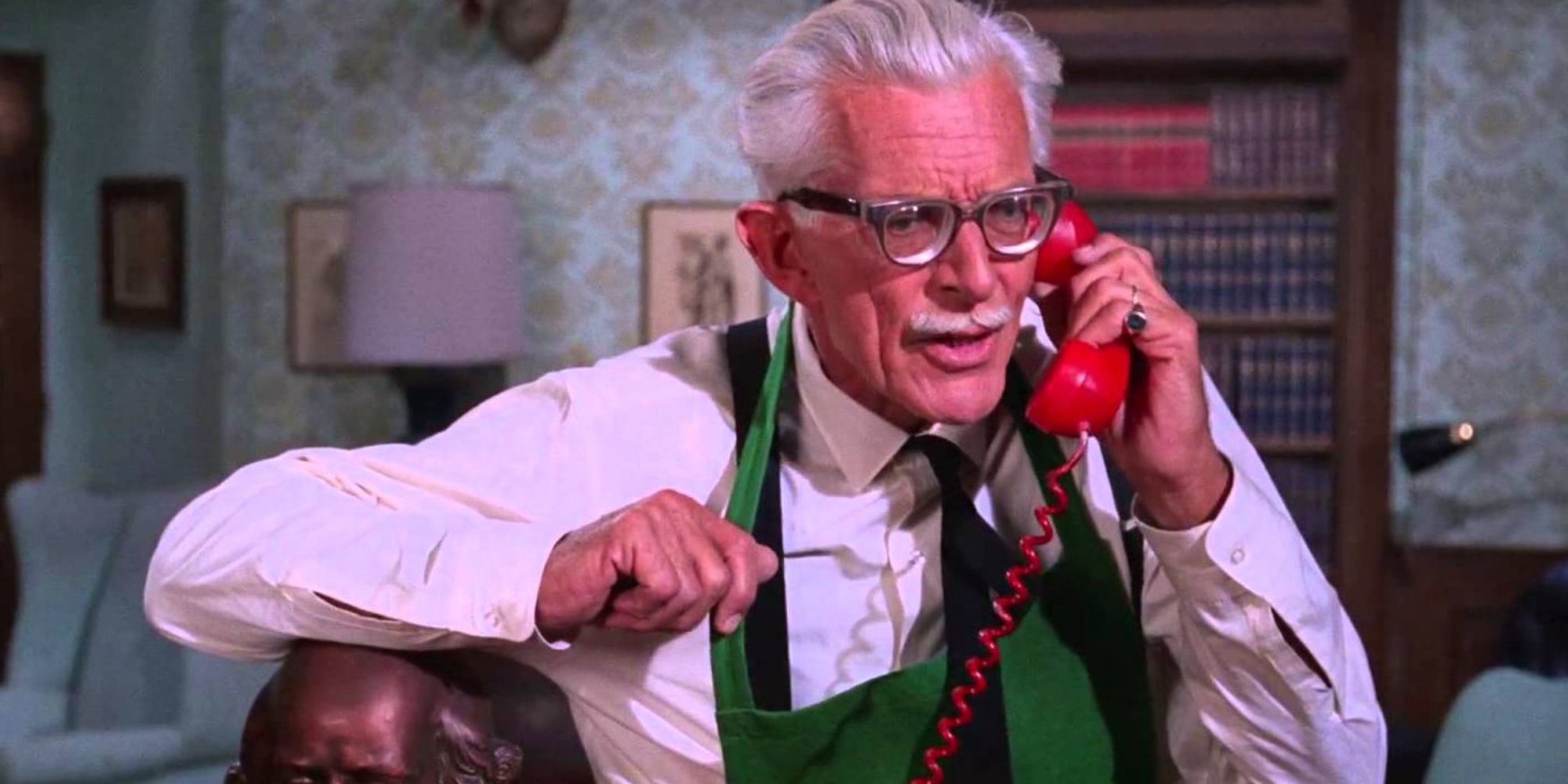 Alfred Pennyworth answering the red Batman telephone in Batman '66