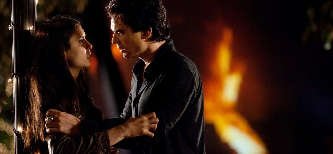 An image of Damon grabbing Elena by the arms aggresively in The Vampire Diaries
