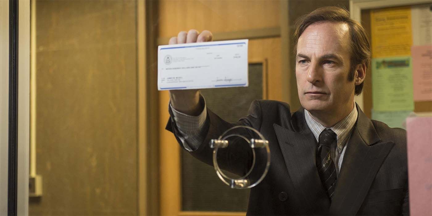 Saul Goodman holds up a check in Better Call Saul 