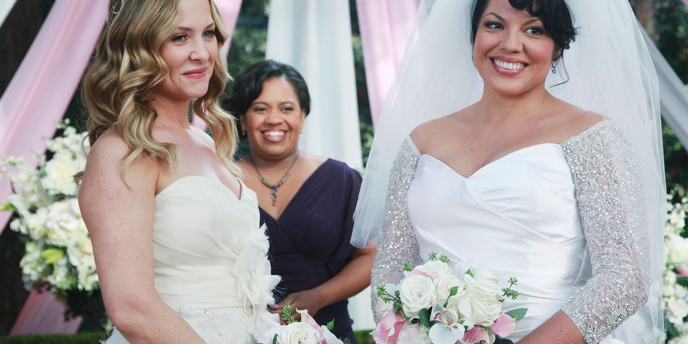 Callie and Arizona standing at the altar in wedding dresses as Dr. Bailey officiates them