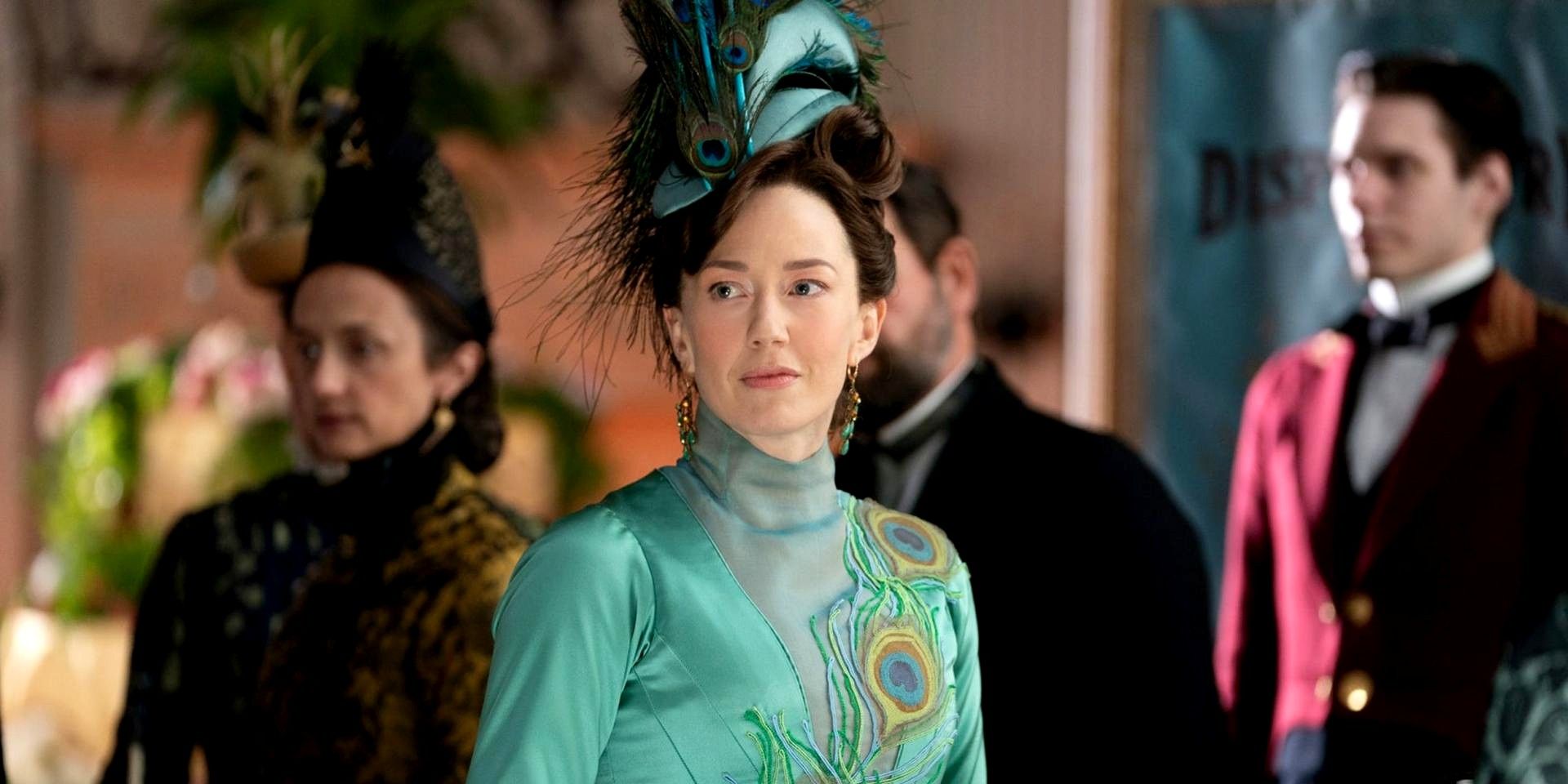 Carrie Coon as Bertha Russell in The Gilded Age. She's wearing a dress with peacock designs on it.
