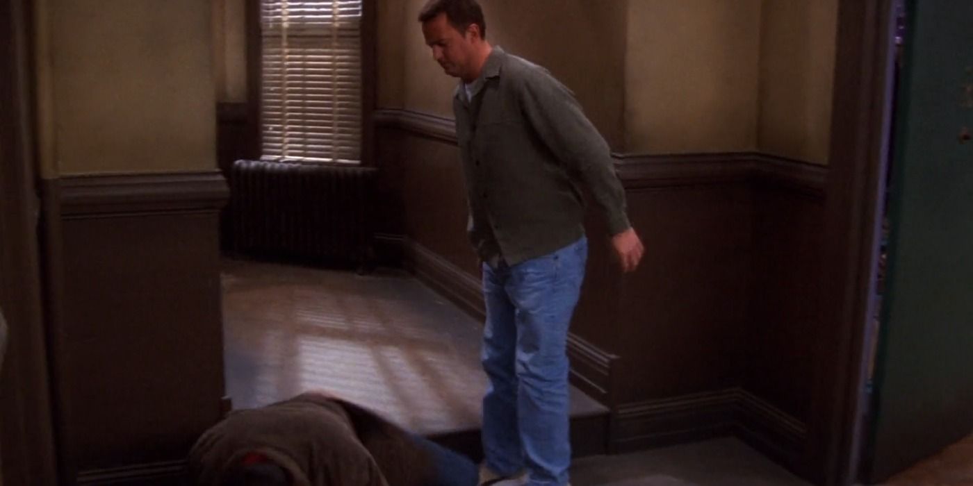 Joey falls to the ground and Chandler stands by in the hallway in Friends
