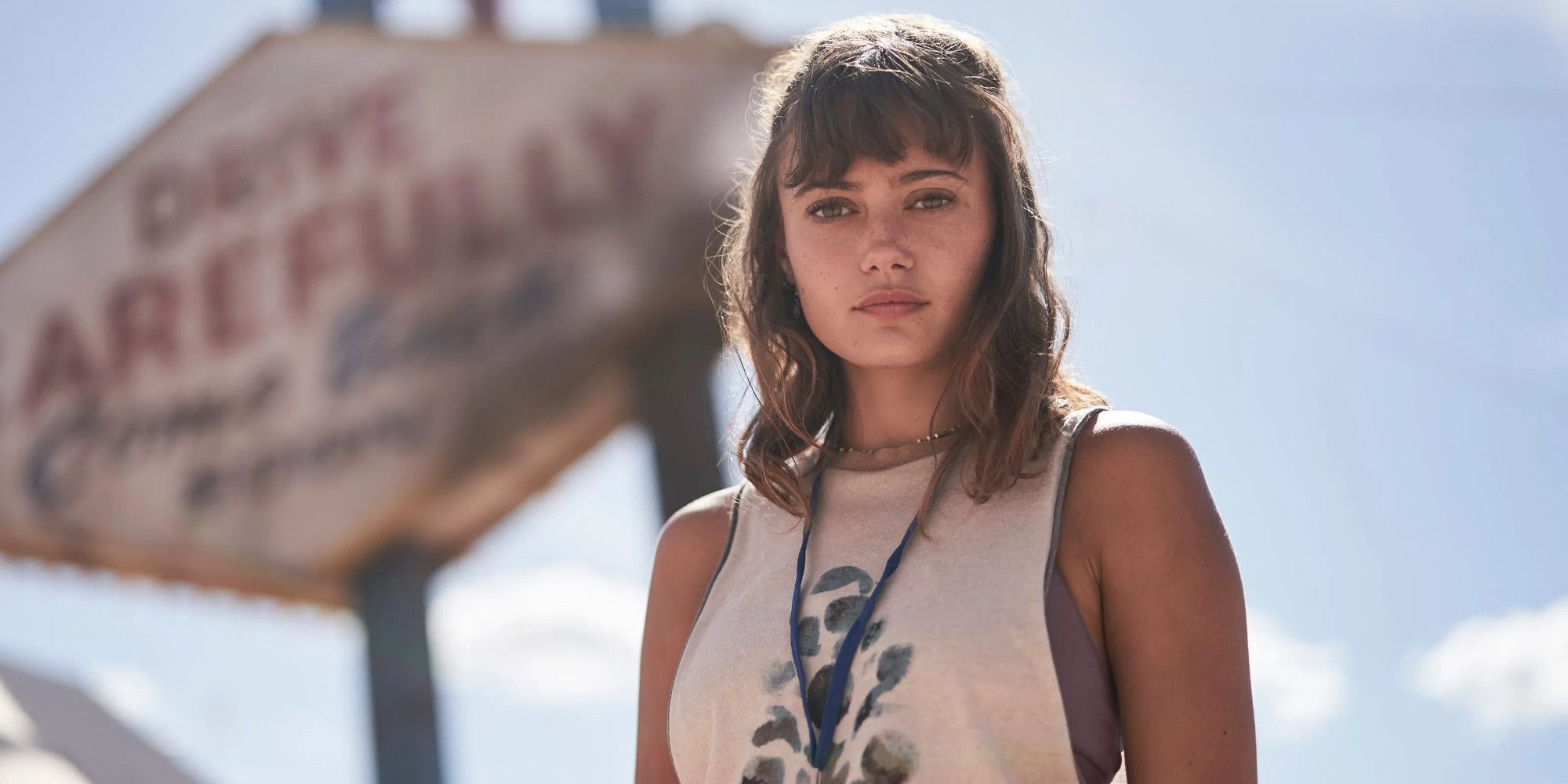 Ella Purnell como Kate Ward em Army of the Dead em pé na frente de uma placa