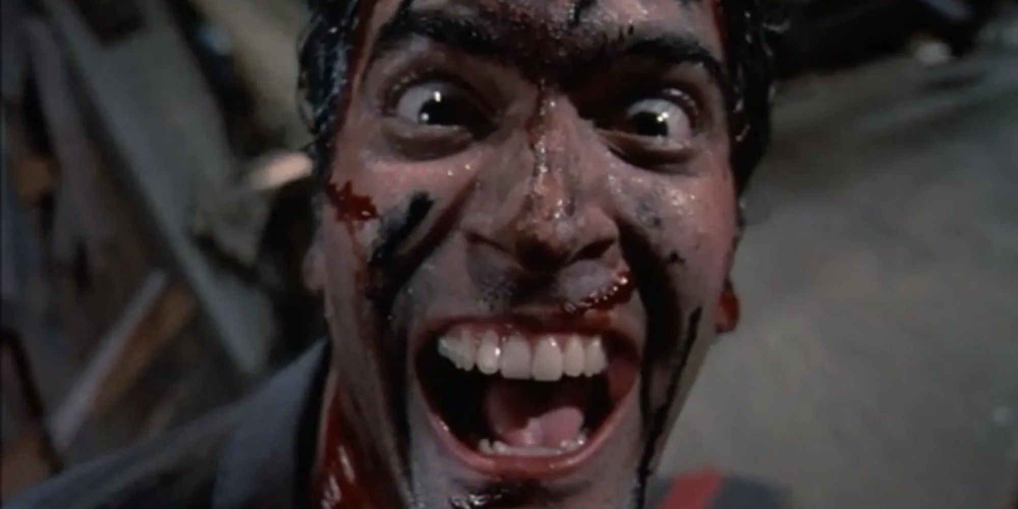Bruce Campbell smiling at the camera in Evil Dead 2