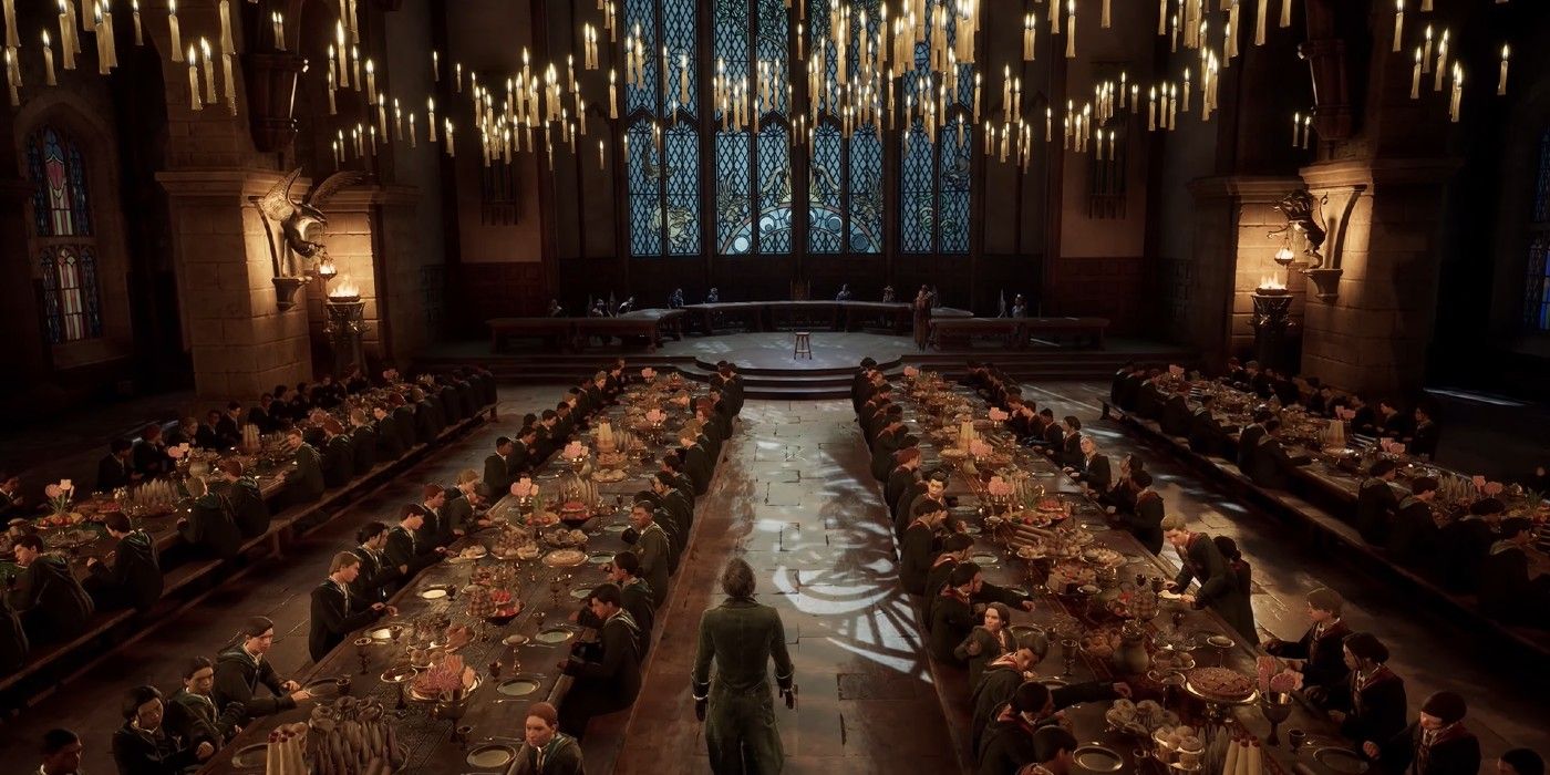 A shot of the Great Hall from Hogwarts Legacy with all four tables filled with students and floating candles above them