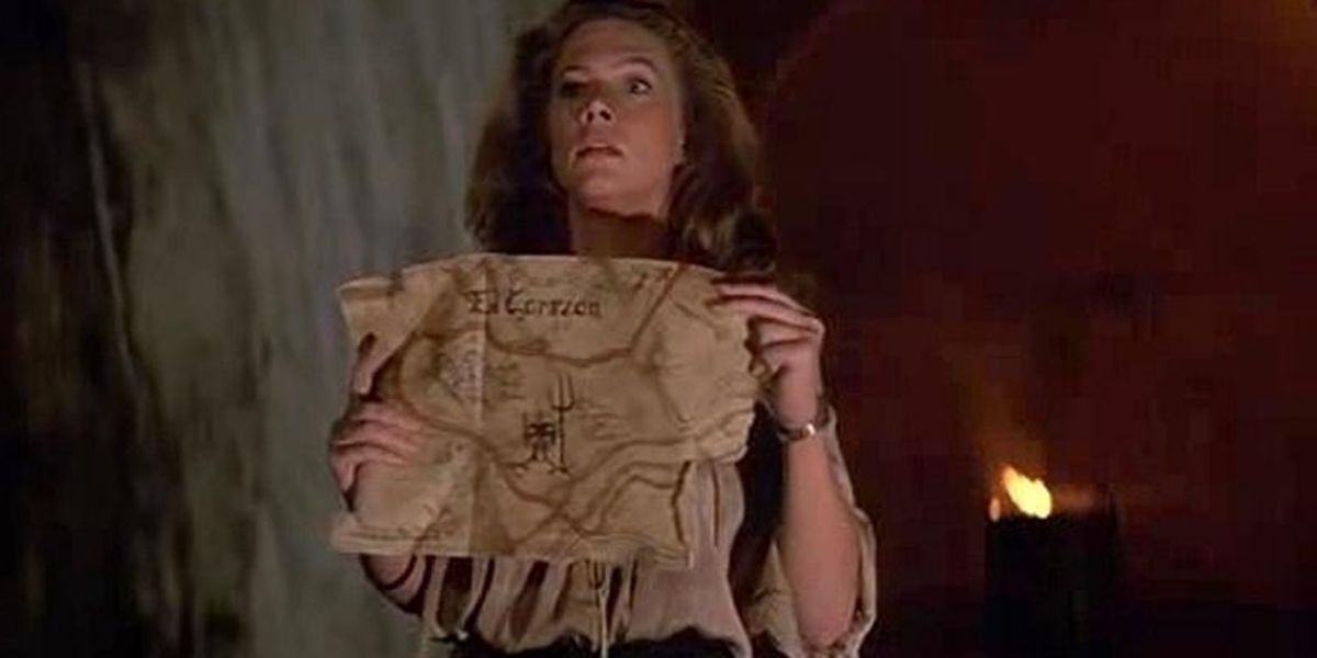 Joan Wilder (Kathleen Turner) con in mano la mappa del tesoro di El Corazon in All'inseguimento della pietra