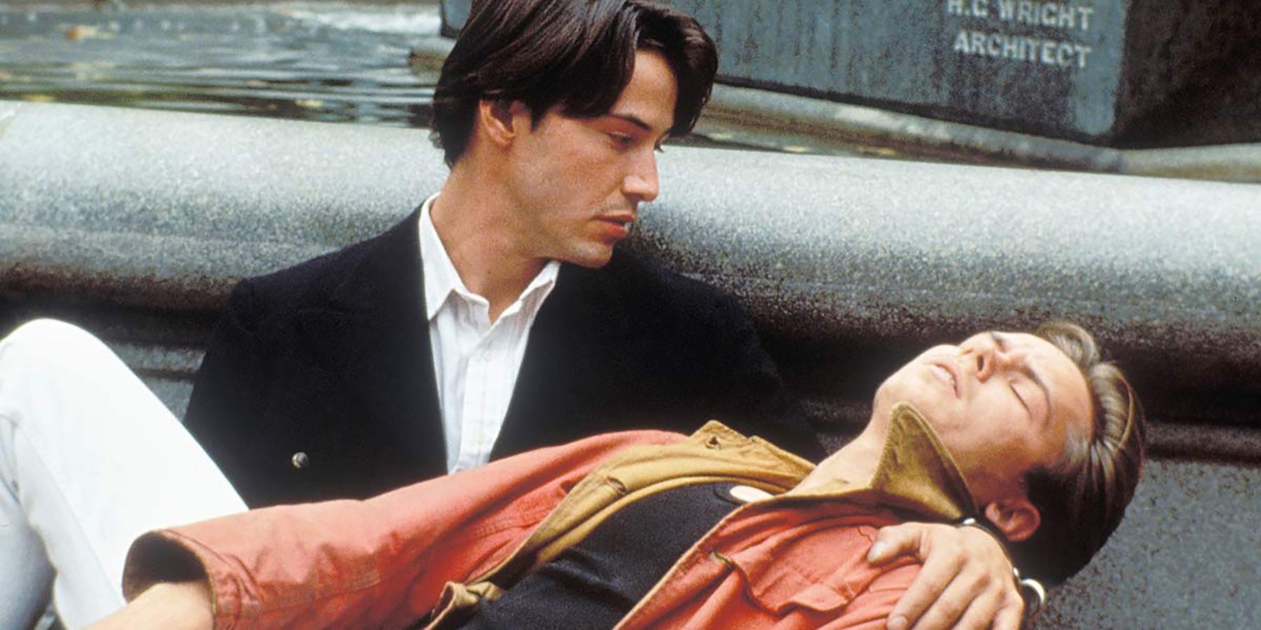 Keanu Reeves holds River Phoenix by a fountain in My Own Private Idaho