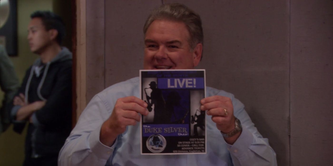 Larry holding a Duke Silver poster on Parks and Rec
