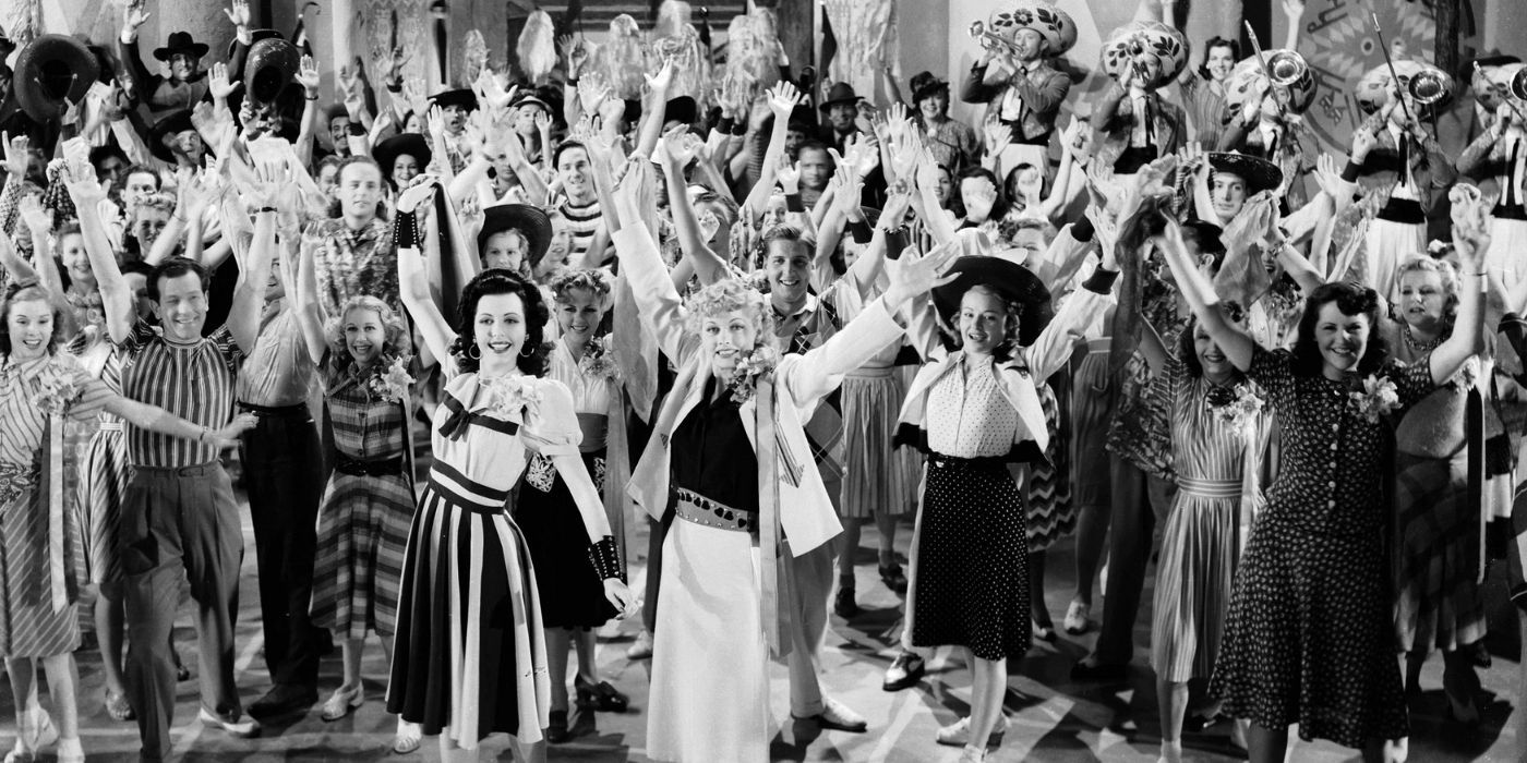 Lucille Ball and the cast of Too Many Girls raising their hands