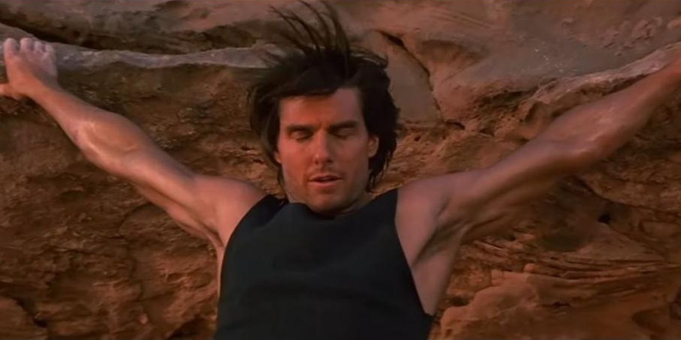 Ethan Hunt holding on to a cliff in Mission Impossible II