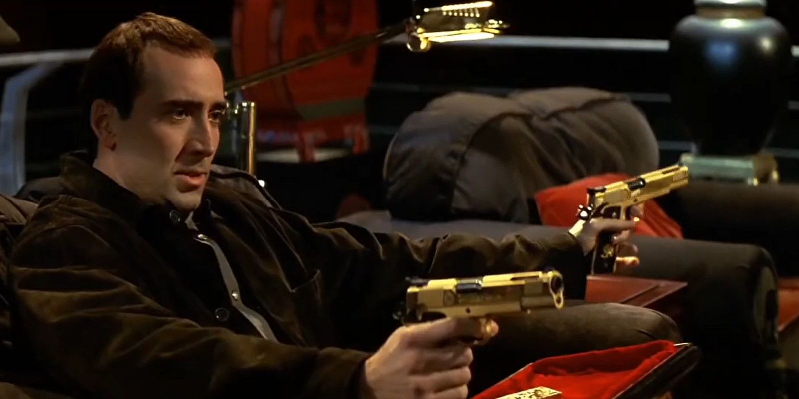 Nicolas Cage points two golden guns in Face/Off