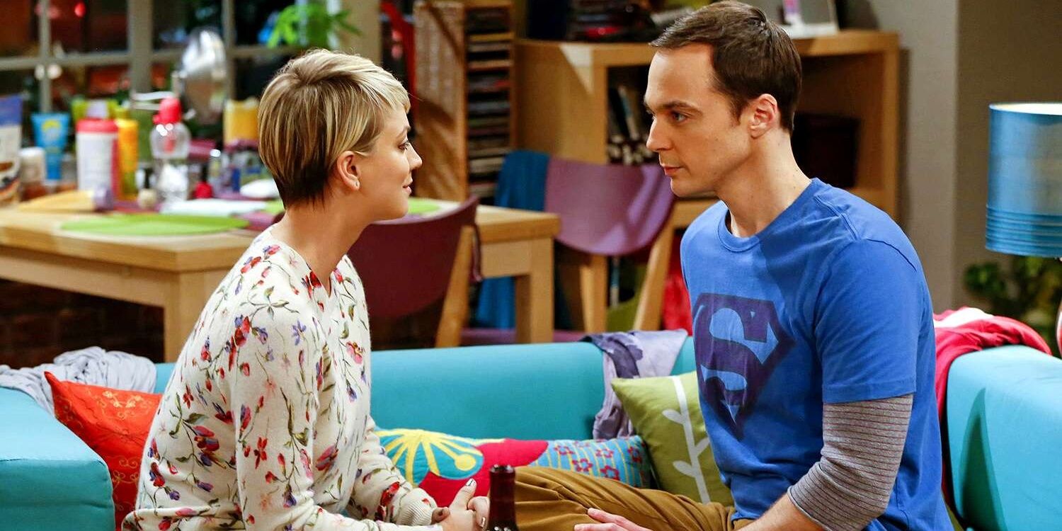 Sheldon e Penny sentados no sofá do apartamento dela olhando nos olhos um do outro em The Big Bang Theory