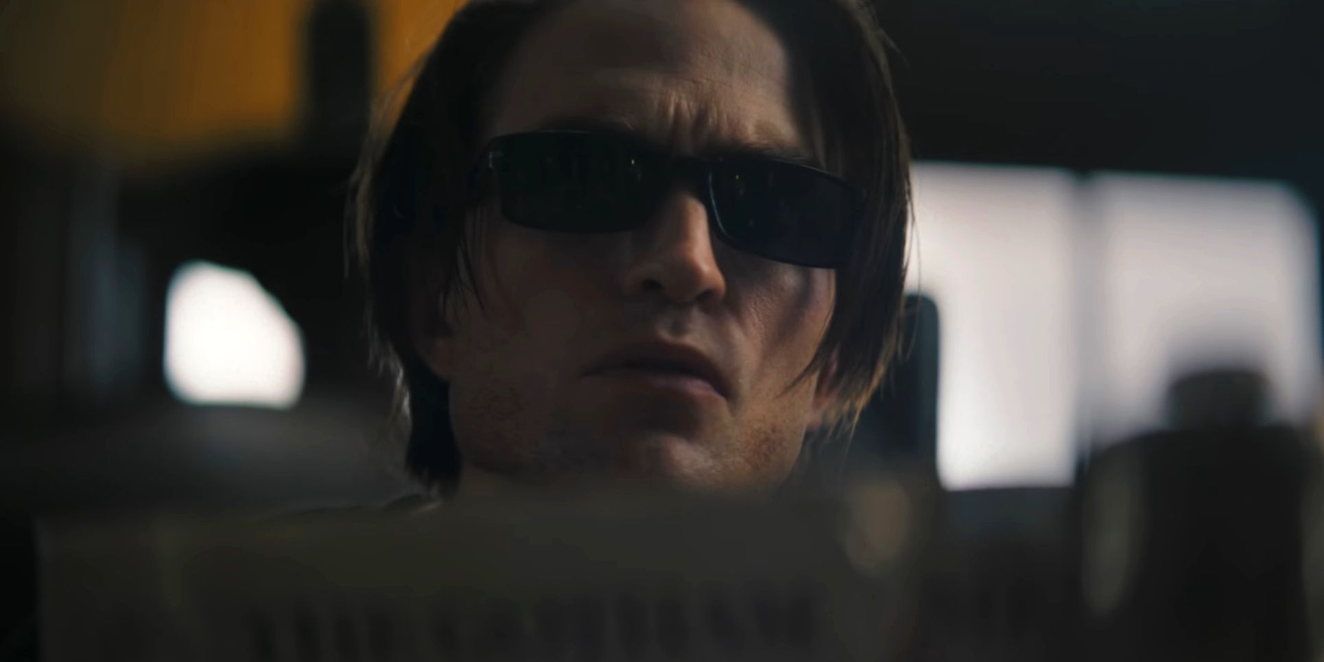 Bruce Wayne wearing shades while reading in The Batman