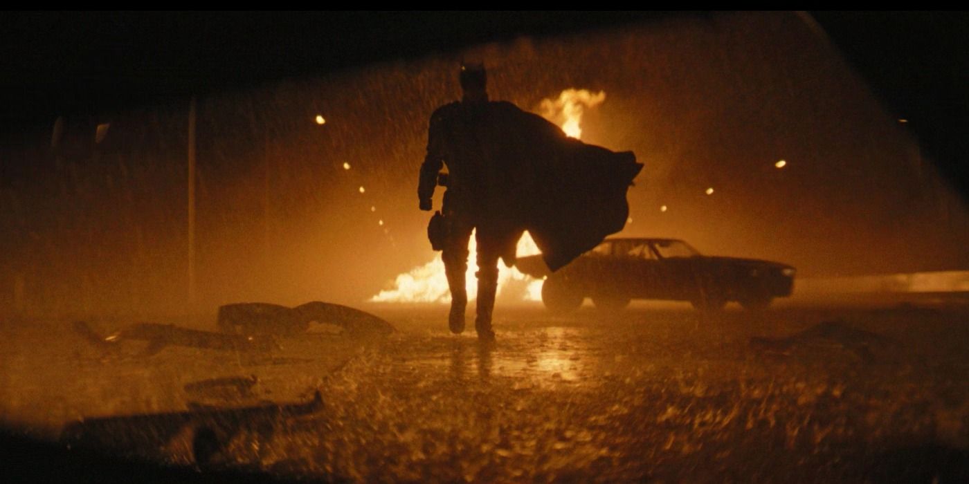 Batman's silhouette as he approaches Penguin in his totaled car