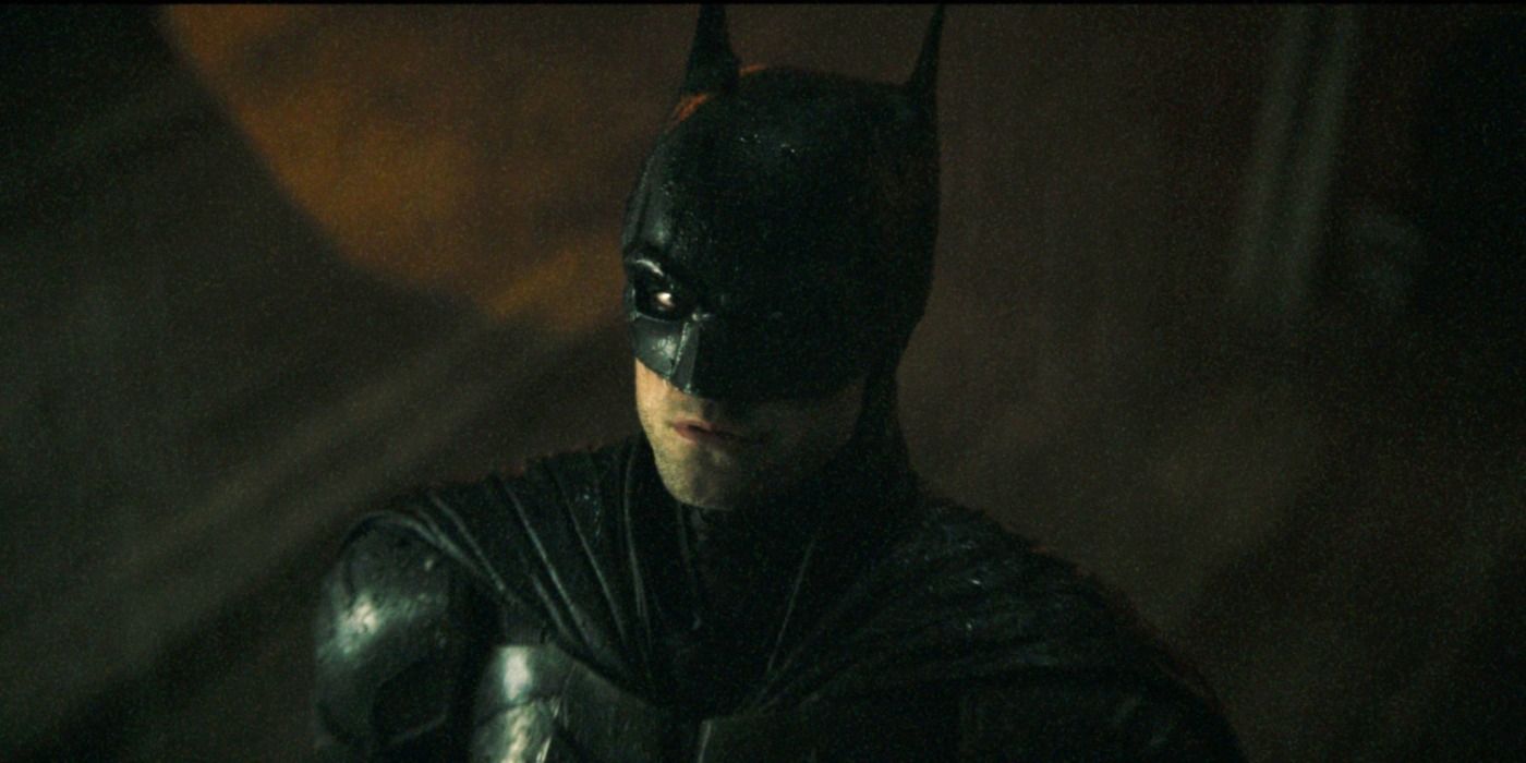 Robert Pattinson as Batman looking up at the Bat-signal