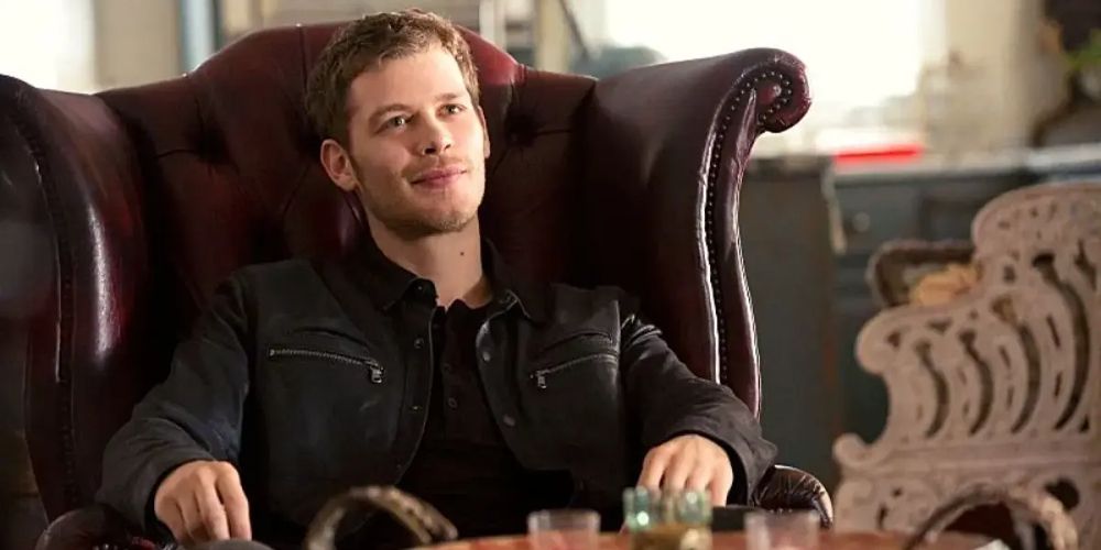 Klaus smiles in a chair in The Originals