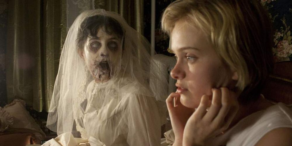 Claire sits next to a ghost in bed in The Innkeepers