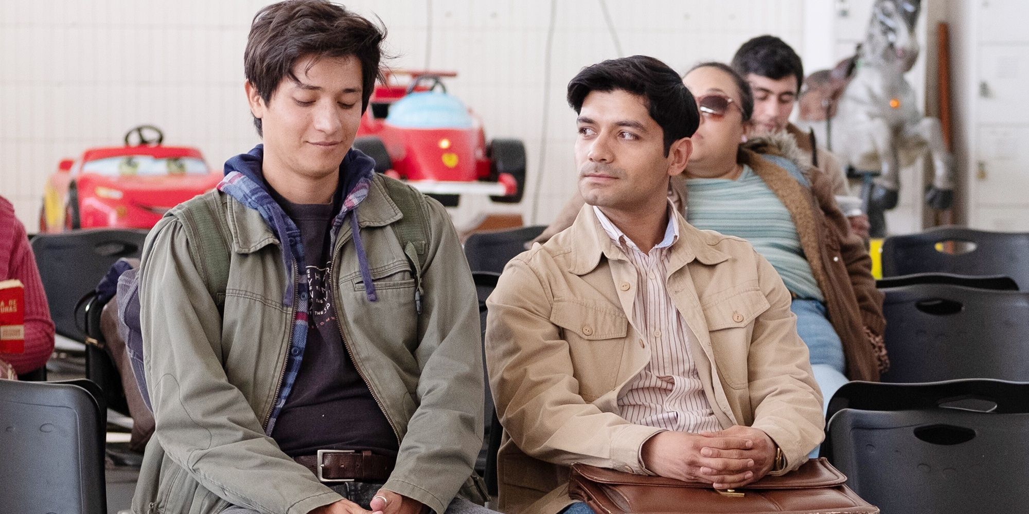 Two young men sit in a waiting room in I Carry You With Me 