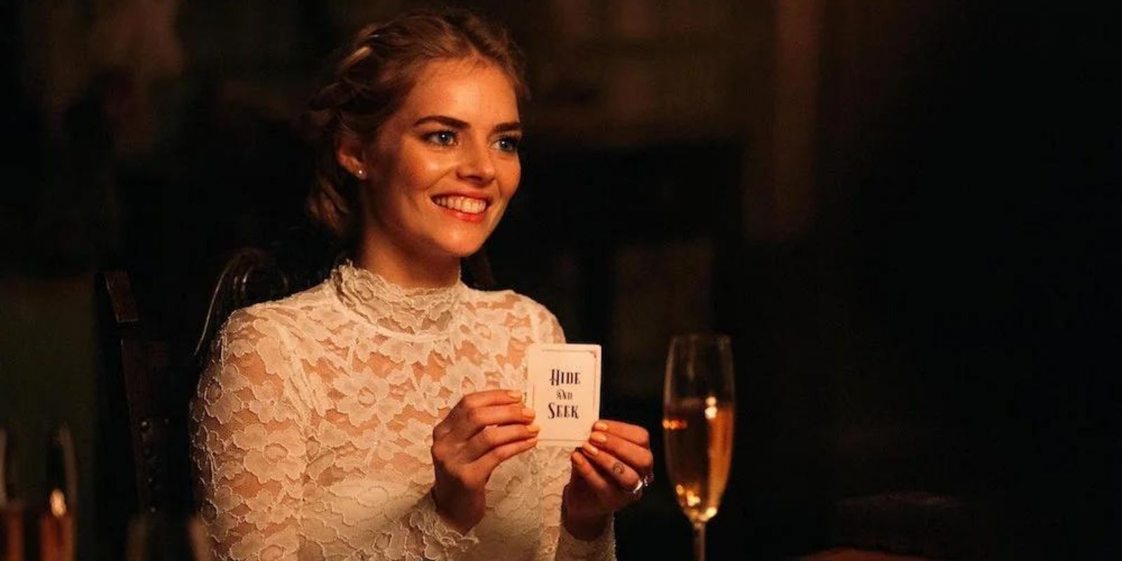 Grace sitting at table holding card