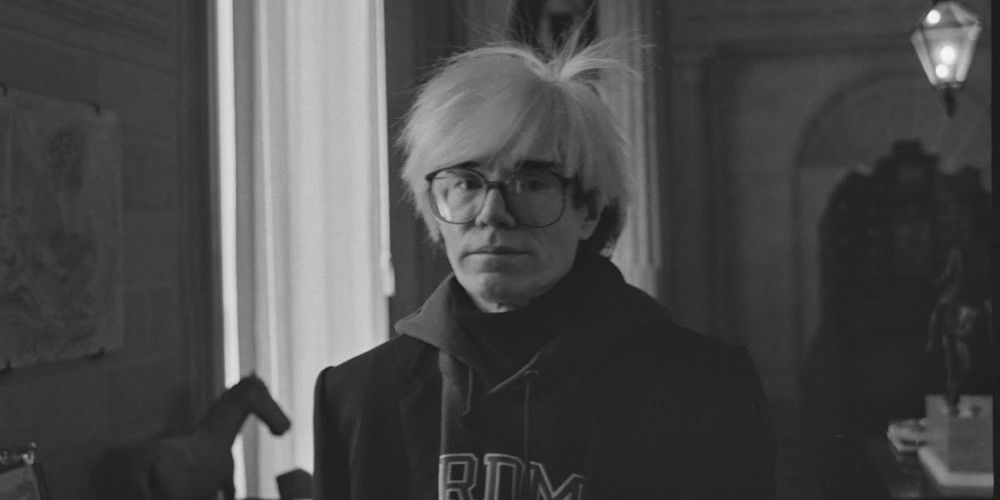Andy Warhol wearing glasses in black and white