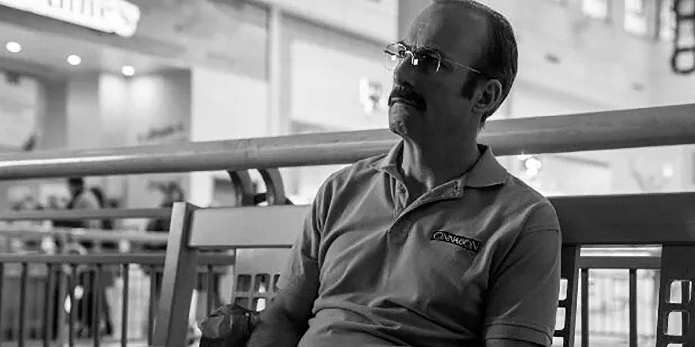 A black and white image of Gene from Better Call Saul sitting on a bench, looking depressed.
