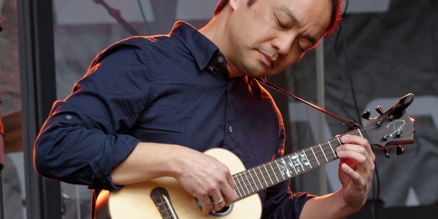 Daniel Ho playing the ukulele on stage.