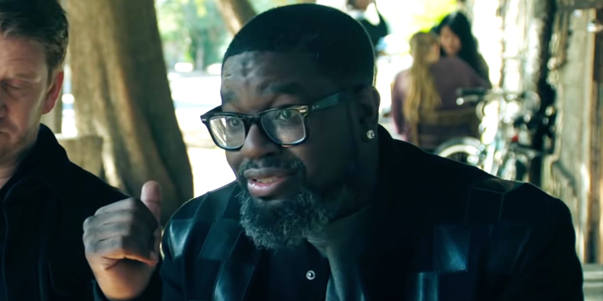 Lil Rel Howery as Grant wearing glasses and speaking at a table in Deep Water.
