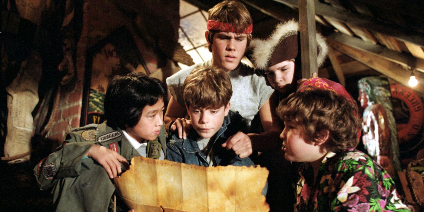The Goonies huddle to examine a treasure map.