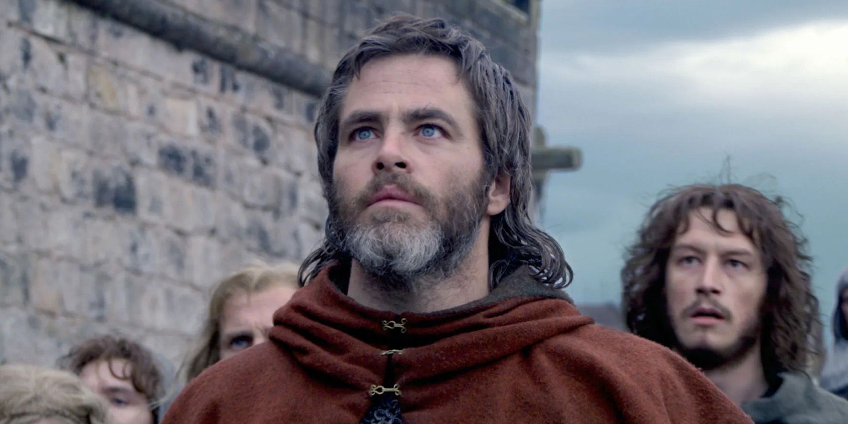 Robert the Brice standing by a castle in Outlaw King.