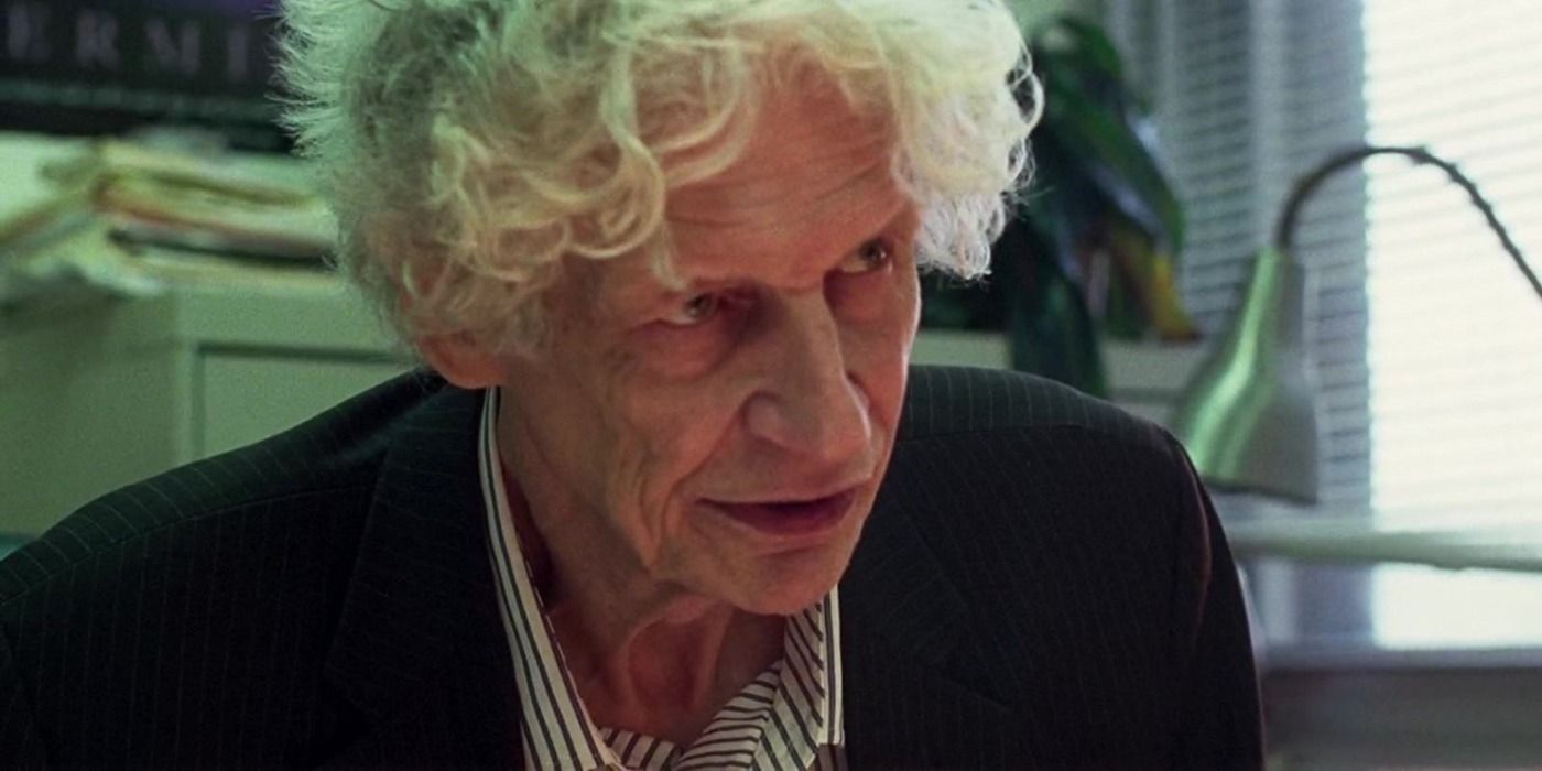 Peter Verby leaning over a desk in Good Time.