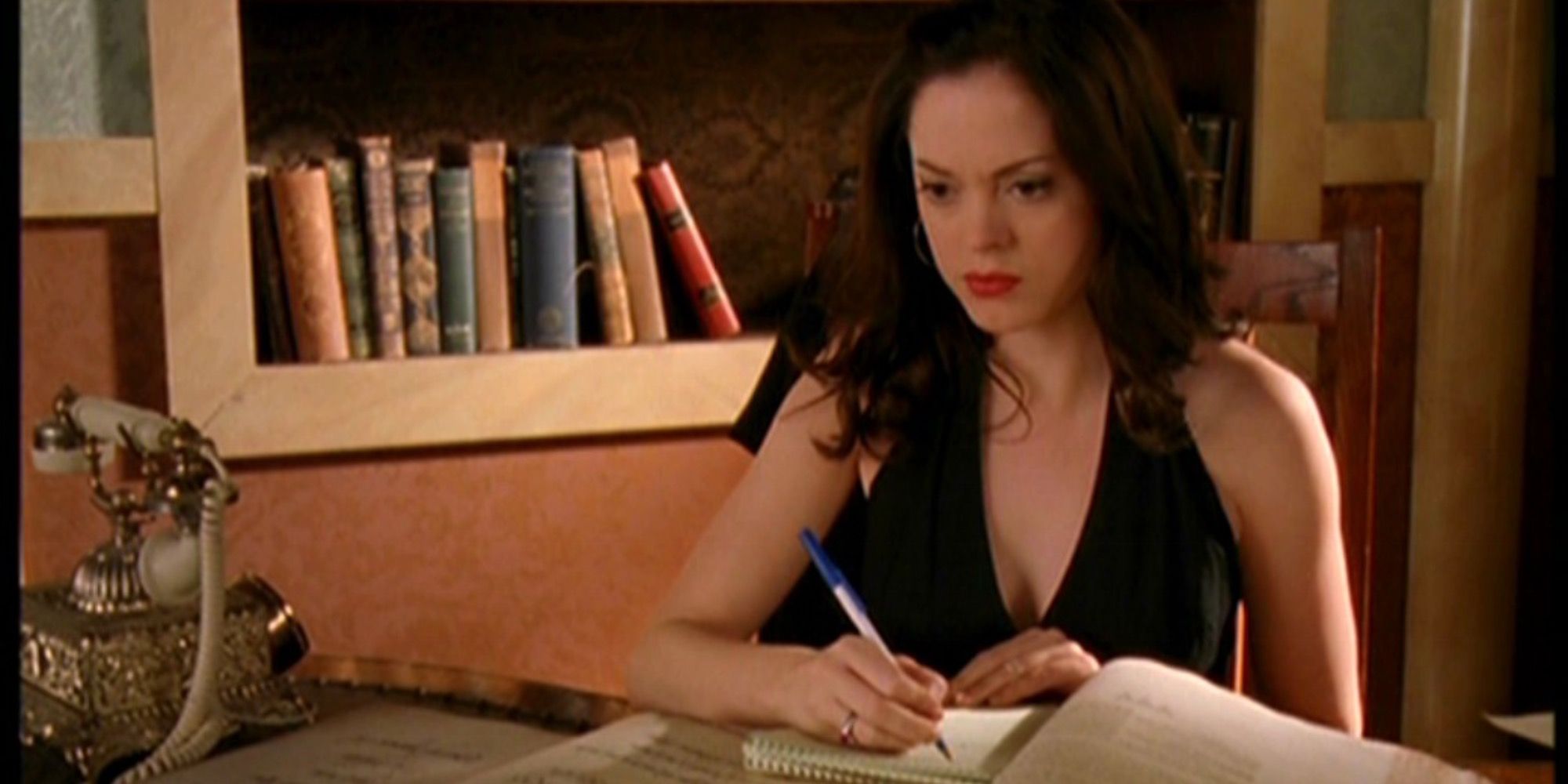 Paige procurando e procurando alguns livros para obter informações em Charmed