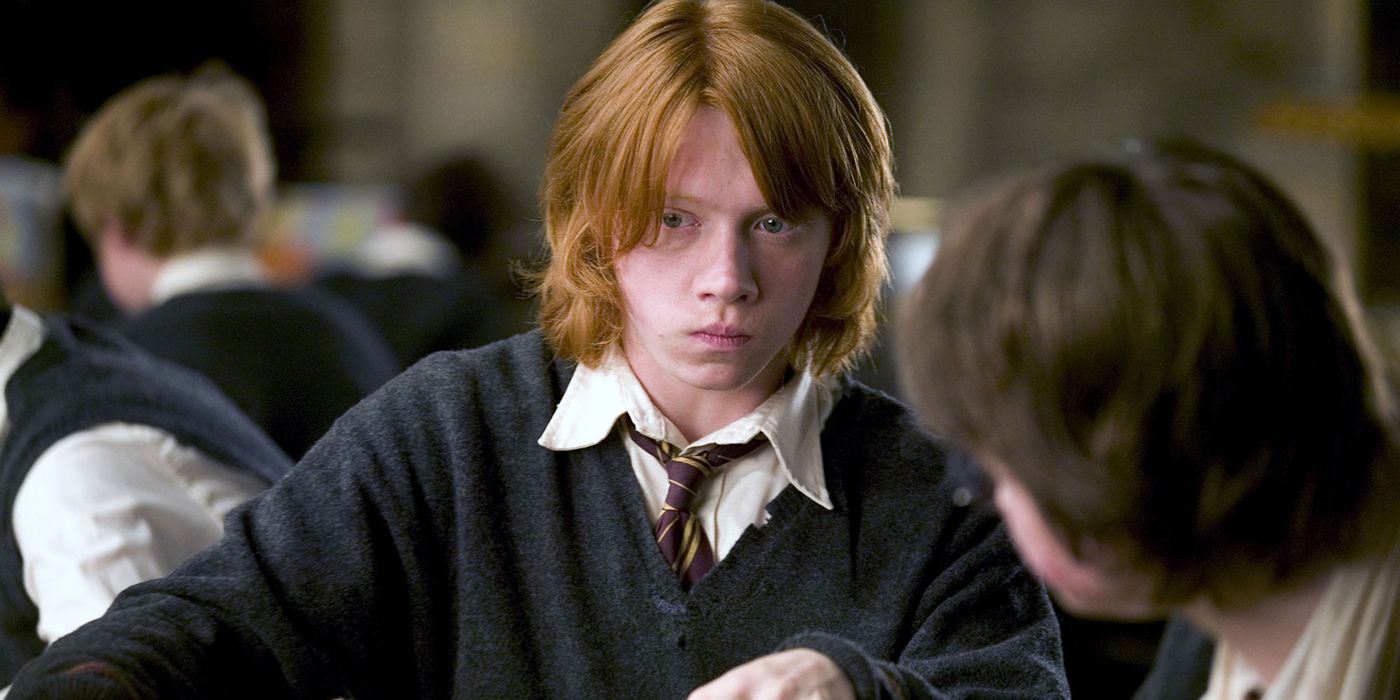 Ron Weasley from Harry Potter, sitting in class in his uniform.