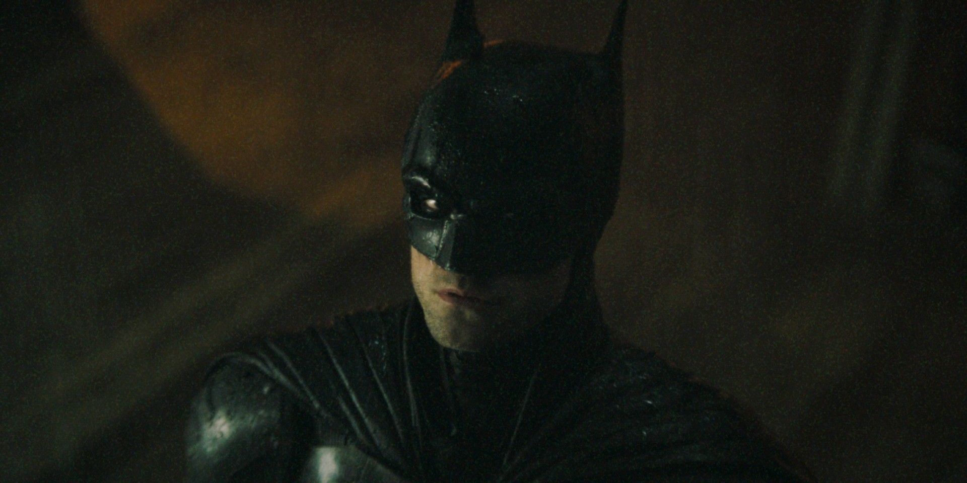 Robert Pattinson in the cowl looking up in The Batman