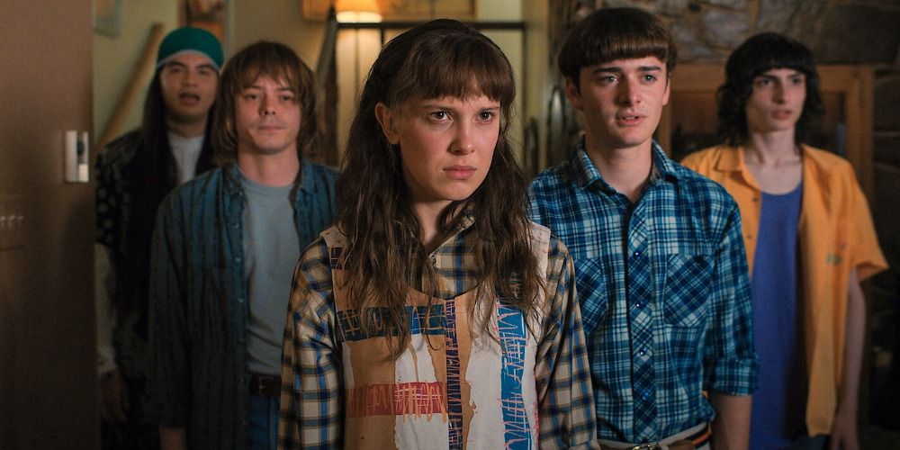 An image of Eleven standing with the group with her hair down in Stranger Things