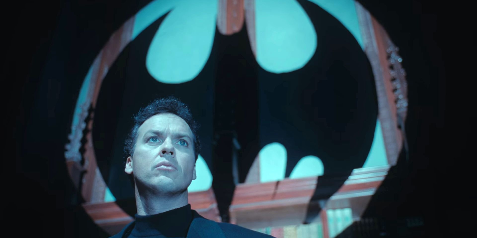 Bruce Wayne stands in front of the Bat Signal in Batman Returns
