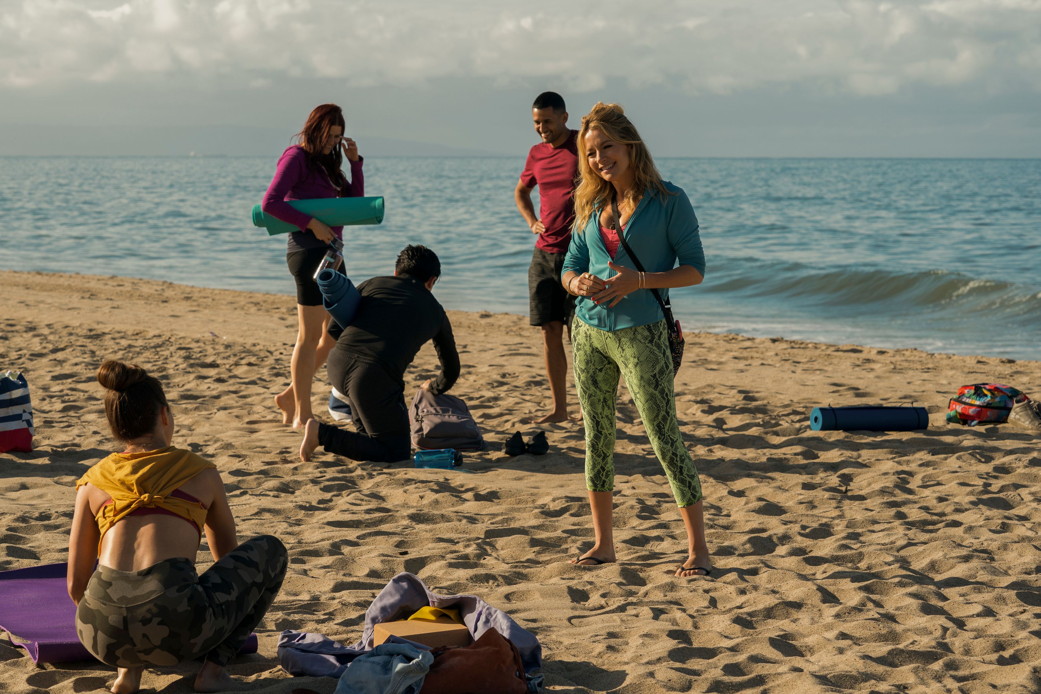 Actress Becki Newton has a conversation on the beach in a scene from The Lincoln Lawyer TV show