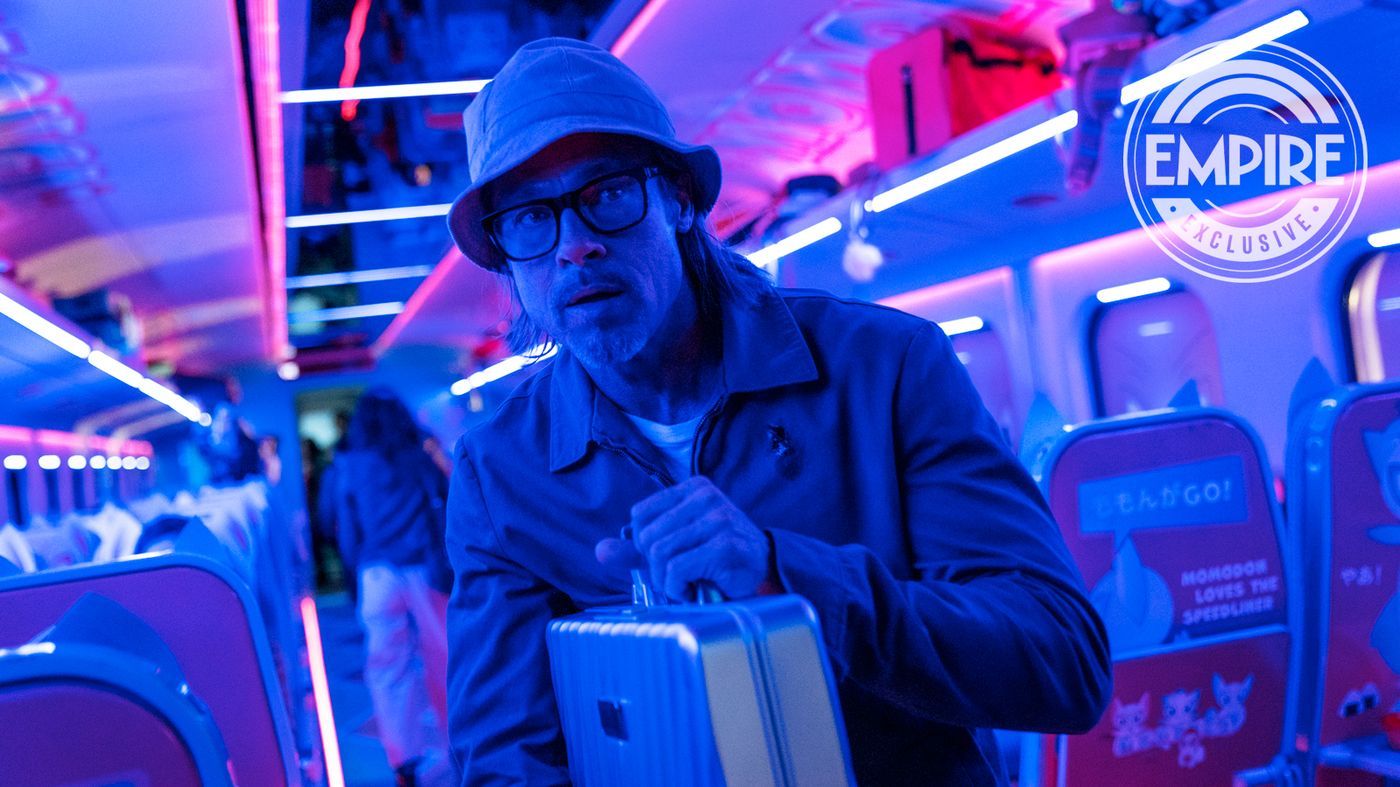 Brad Pitt in the movie Bullet Train in a train car wearing a hat and holding a briefcase
