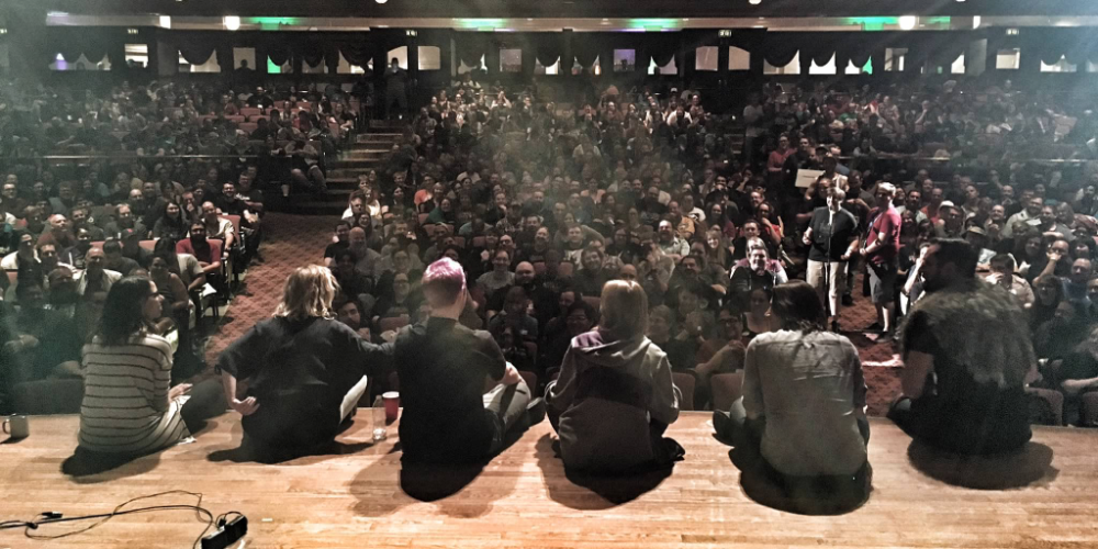 The cast of Critical Role sitting in front of a live crowd