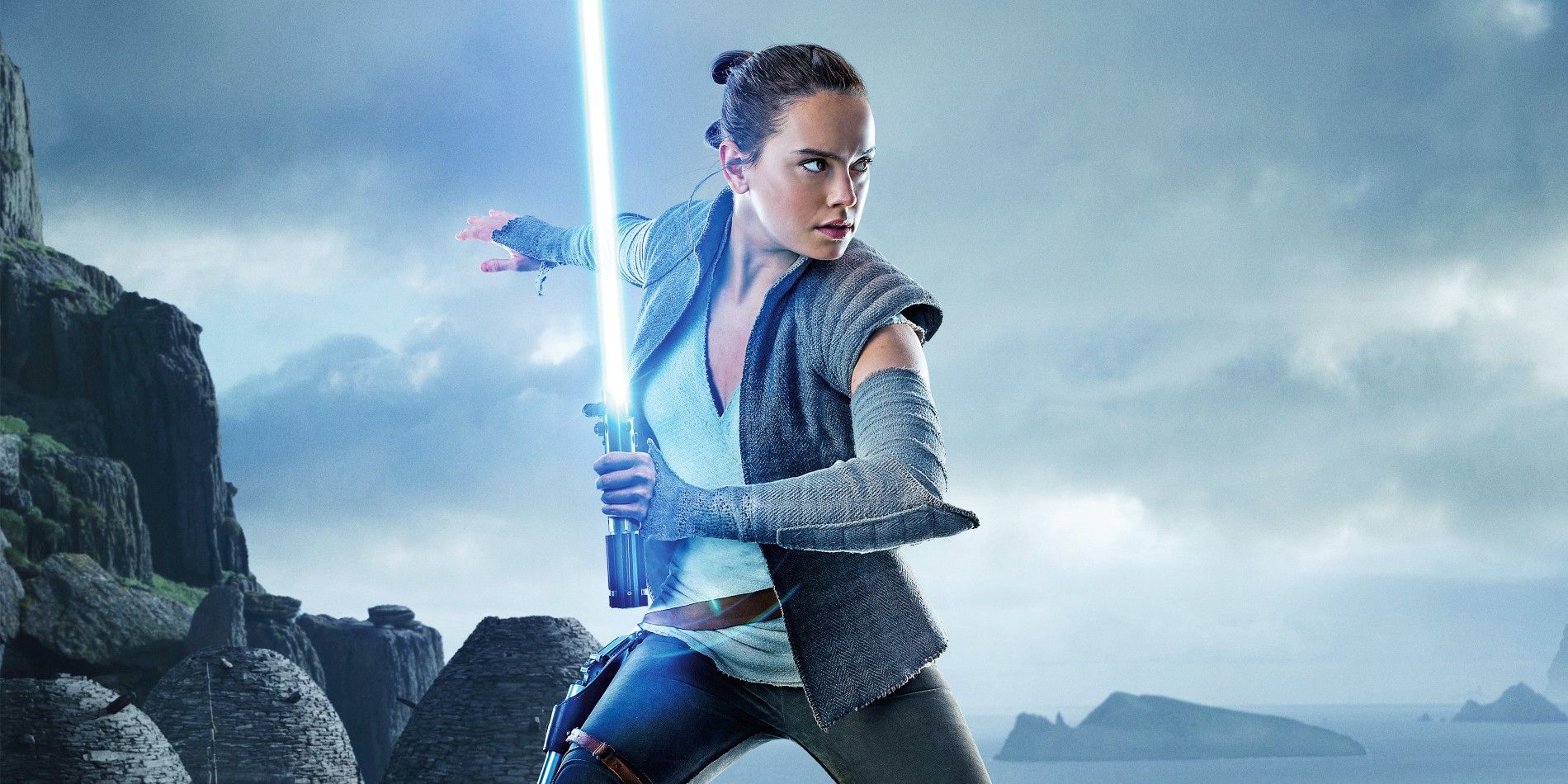 Daisy Ridley as Rey in Star Wars wielding a light saber.
